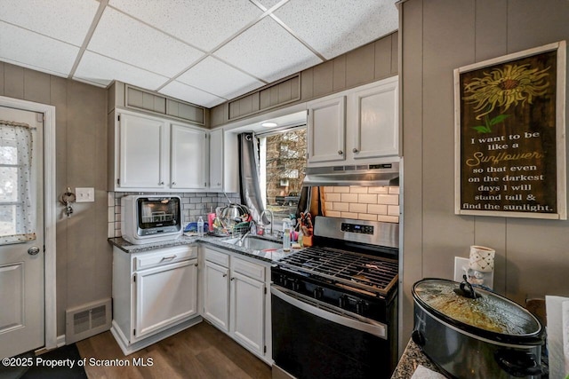 kitchen with visible vents, white cabinets, stainless steel range with gas stovetop, a sink, and under cabinet range hood