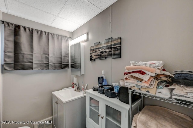 bathroom featuring a paneled ceiling and vanity