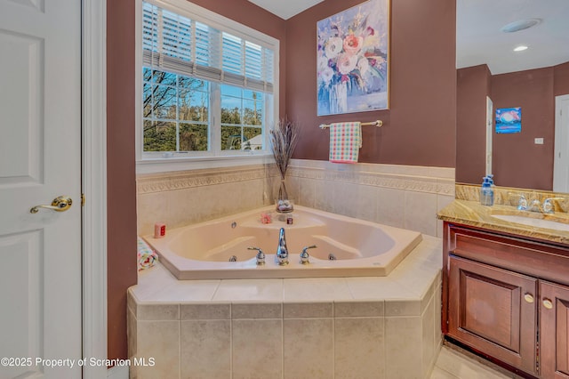 bathroom featuring a relaxing tiled tub and vanity