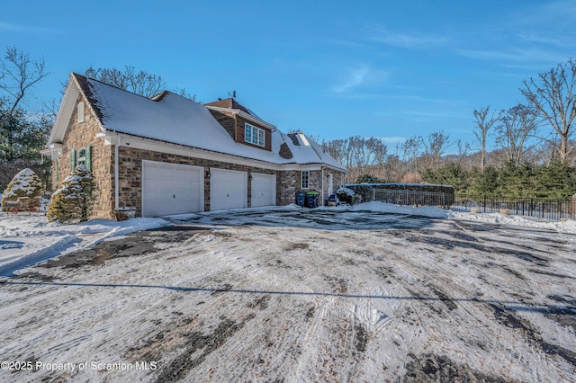 view of snowy exterior featuring a garage