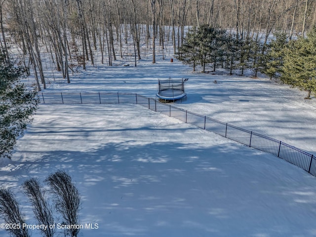 yard covered in snow with a trampoline