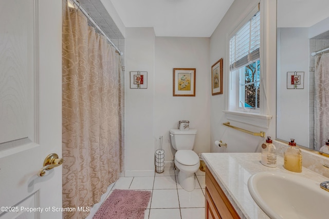 bathroom with tile patterned flooring, vanity, a wealth of natural light, and toilet