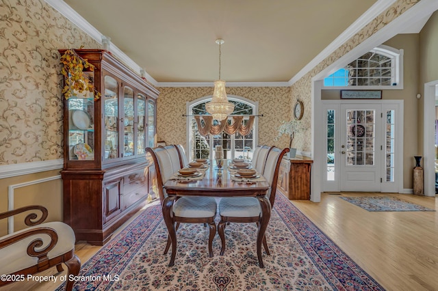 dining space featuring crown molding, a notable chandelier, and light hardwood / wood-style floors