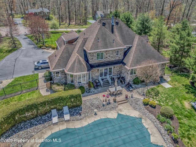 8 Eight Iron Dr, Mountaintop, PA 18707 - back of house featuring stone siding, a fenced backyard, a patio area, a shingled roof, and a chimney