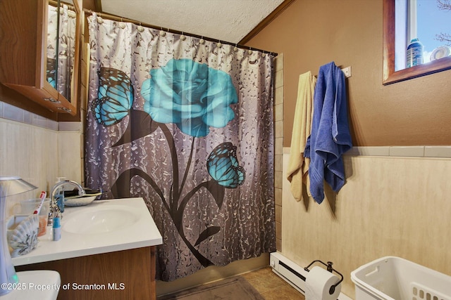 full bathroom with toilet, a baseboard radiator, a textured ceiling, tile patterned flooring, and vanity