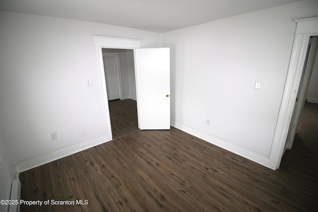 unfurnished room with dark wood-type flooring