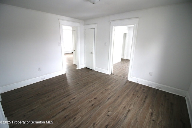 unfurnished room with dark wood-type flooring