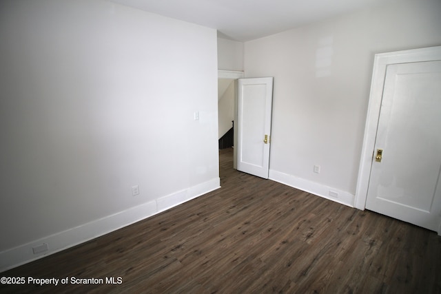 unfurnished room featuring dark wood-type flooring