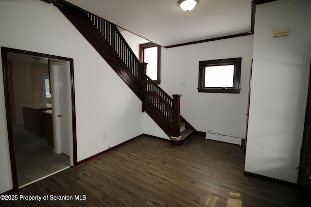 interior space with baseboard heating, wood-type flooring, and a healthy amount of sunlight