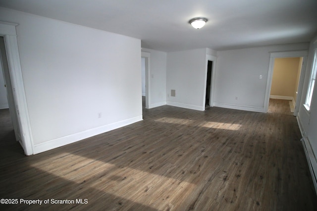 unfurnished room featuring dark wood-type flooring and a baseboard radiator