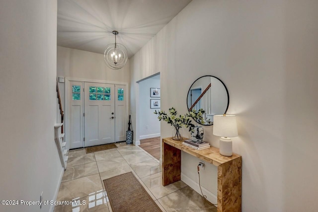 tiled foyer featuring a chandelier