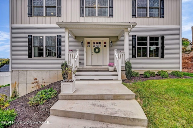 property entrance featuring a lawn