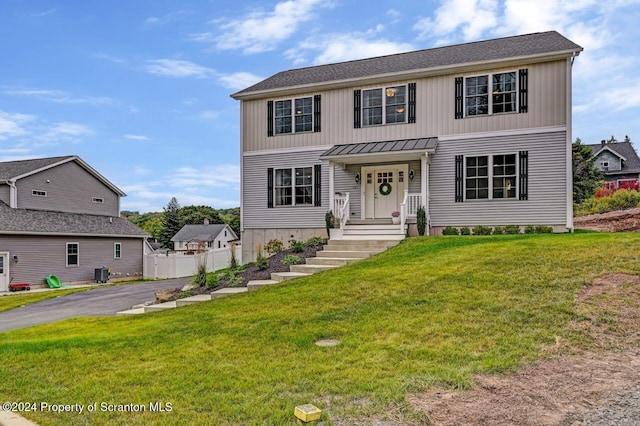 view of front of property with a front yard and central AC unit