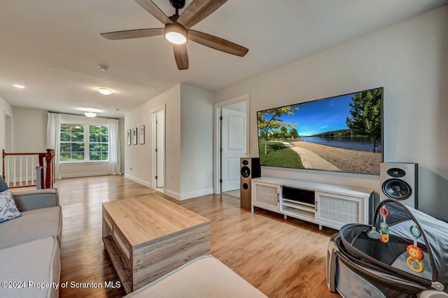 living room with ceiling fan and light wood-type flooring