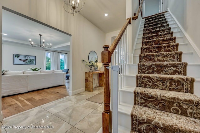 staircase with tile patterned flooring and a chandelier