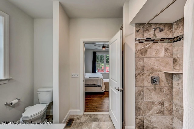 bathroom featuring ceiling fan, toilet, and tiled shower