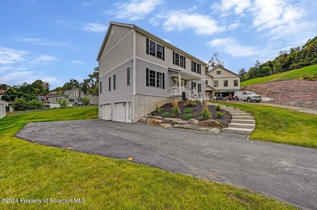 view of front of home with a porch, a garage, and a front lawn