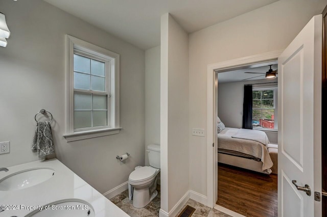 bathroom featuring ceiling fan, plenty of natural light, vanity, and toilet