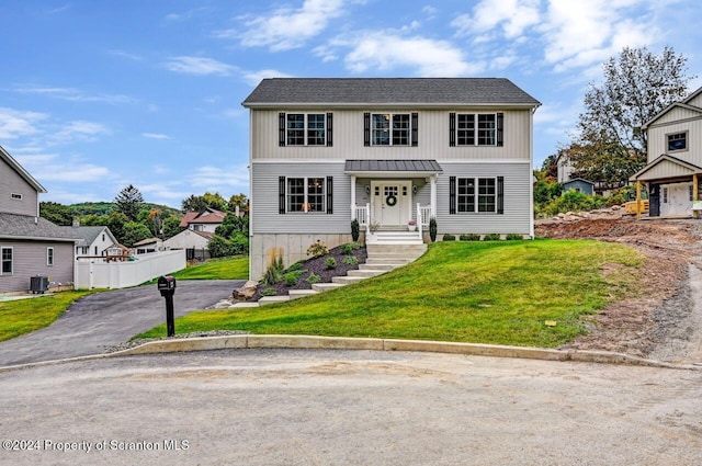 view of front of property featuring a front lawn and central air condition unit