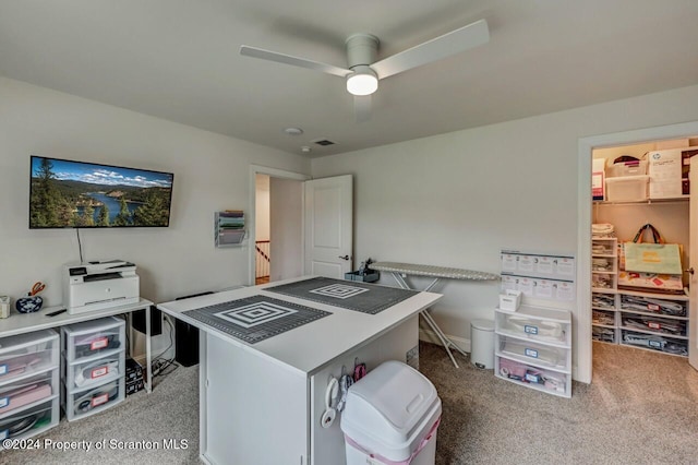 carpeted office space with ceiling fan