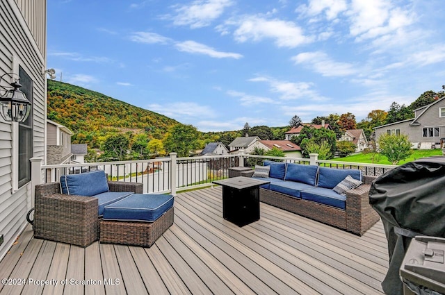 deck featuring an outdoor living space with a fire pit and a grill