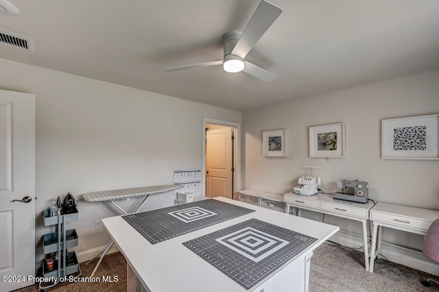 carpeted office space featuring ceiling fan