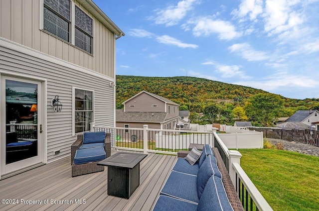 wooden deck featuring a mountain view and a yard