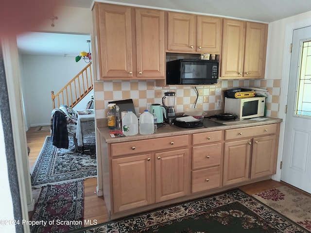 kitchen featuring tasteful backsplash, light brown cabinetry, and light wood-type flooring