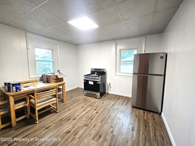 office with baseboards, wood-type flooring, and a paneled ceiling