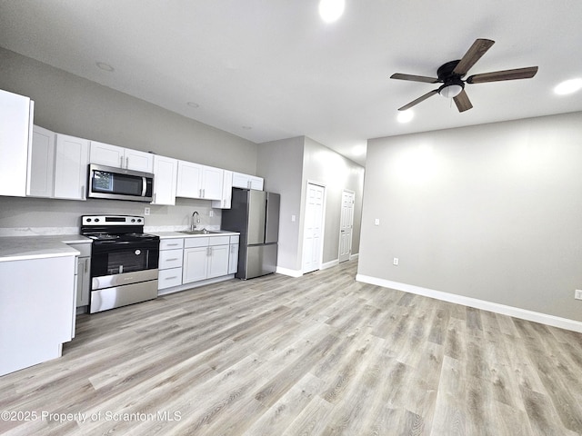 kitchen with white cabinetry, light countertops, stainless steel appliances, and light wood-style floors