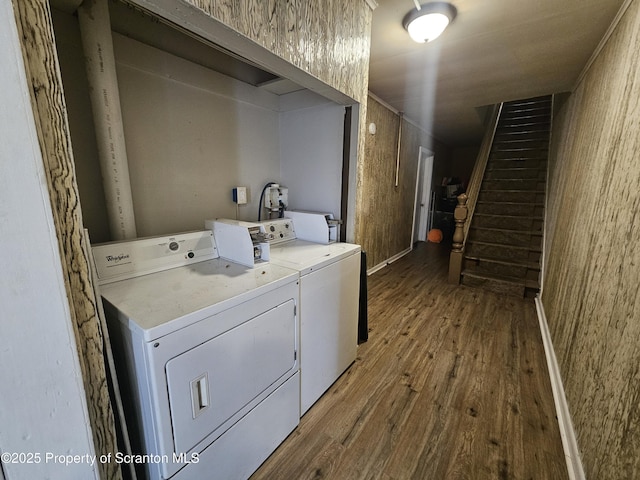 clothes washing area featuring laundry area, separate washer and dryer, and wood finished floors
