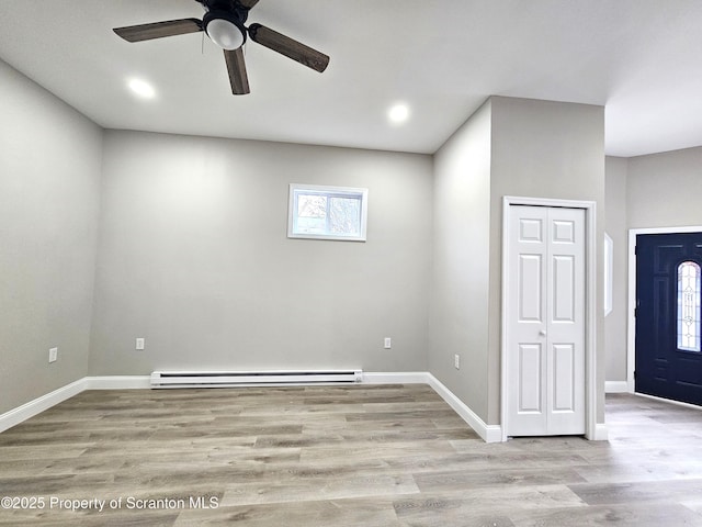 interior space with wood finished floors, baseboards, a baseboard heating unit, ceiling fan, and recessed lighting