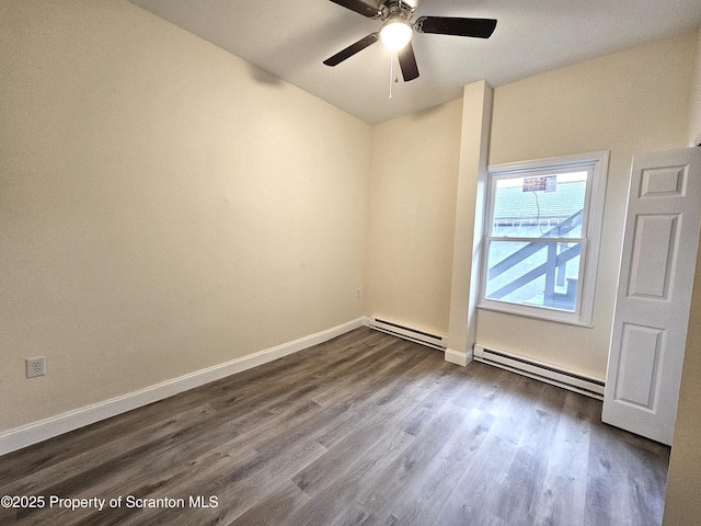 spare room featuring ceiling fan, baseboards, dark wood-type flooring, and baseboard heating