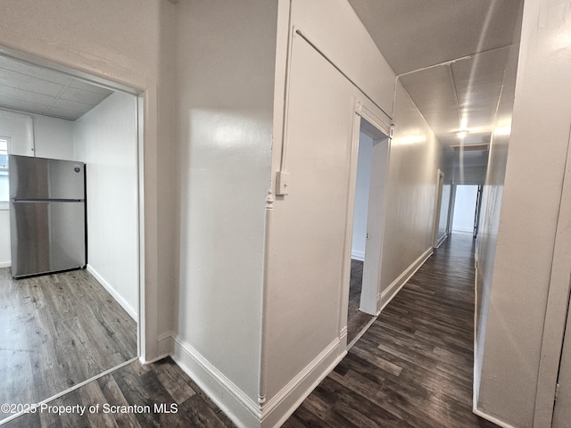 hallway with wood finished floors and baseboards