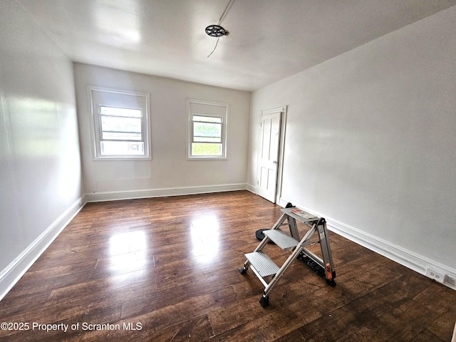 unfurnished room with baseboards and wood finished floors