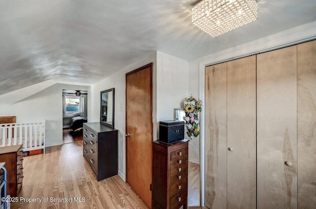 bedroom featuring light wood-type flooring and vaulted ceiling