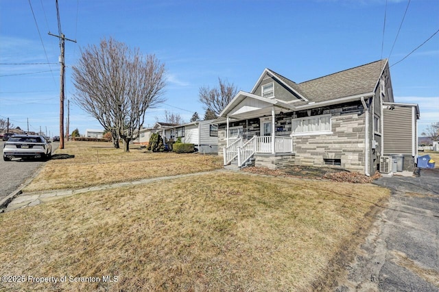 view of front of house featuring a porch, driveway, a front yard, and roof with shingles