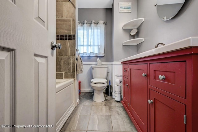 full bathroom featuring a wainscoted wall, toilet, and washer / dryer