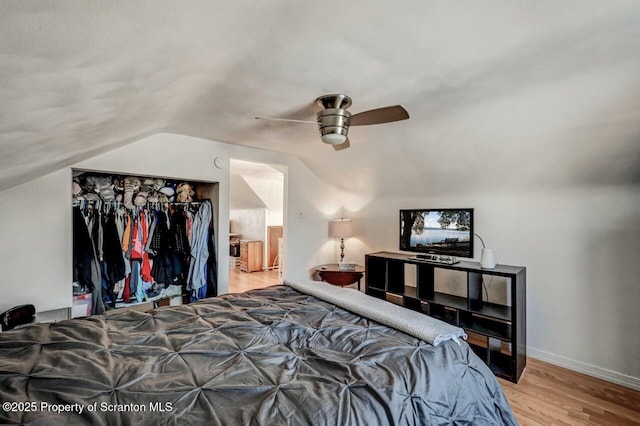 bedroom with ceiling fan, baseboards, wood finished floors, and vaulted ceiling