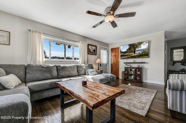 living room featuring dark wood-type flooring and ceiling fan