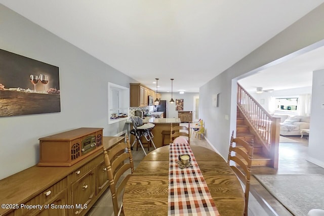 dining area featuring ceiling fan, stairs, and baseboards