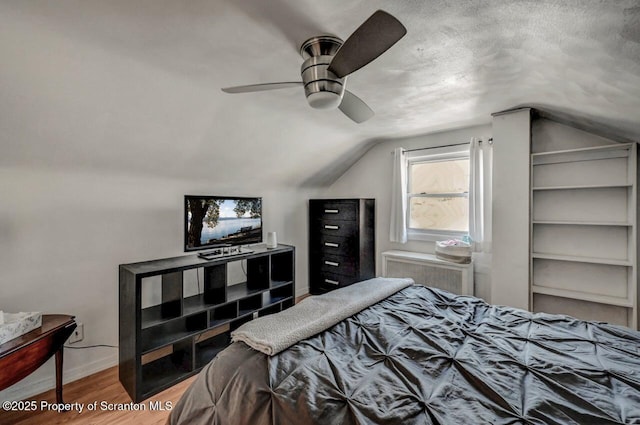 bedroom featuring baseboards, wood finished floors, a ceiling fan, and vaulted ceiling