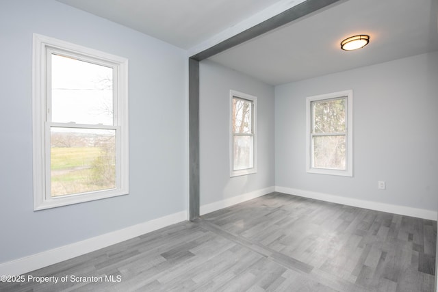 unfurnished room with baseboards and wood finished floors