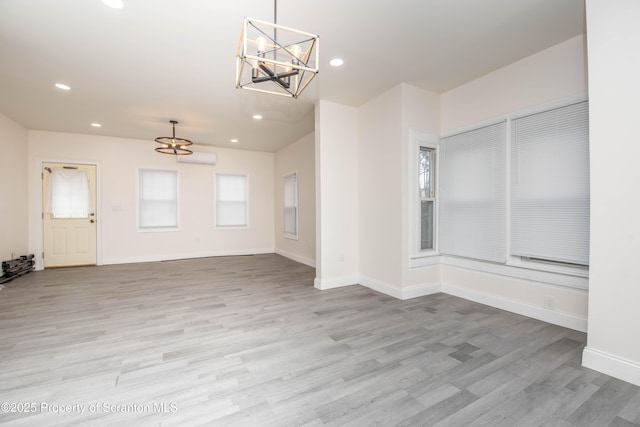 unfurnished room with baseboards, a notable chandelier, wood finished floors, and recessed lighting