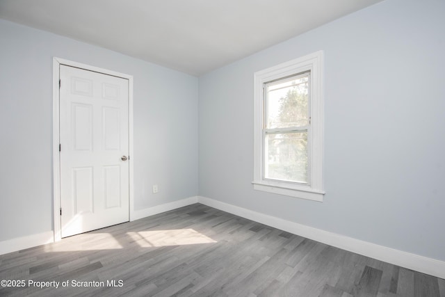 empty room with baseboards and wood finished floors