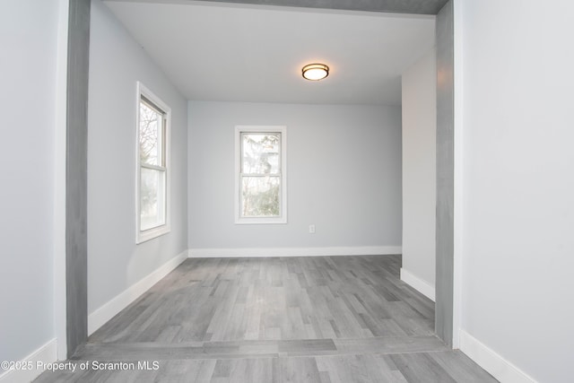 unfurnished room with baseboards and wood finished floors