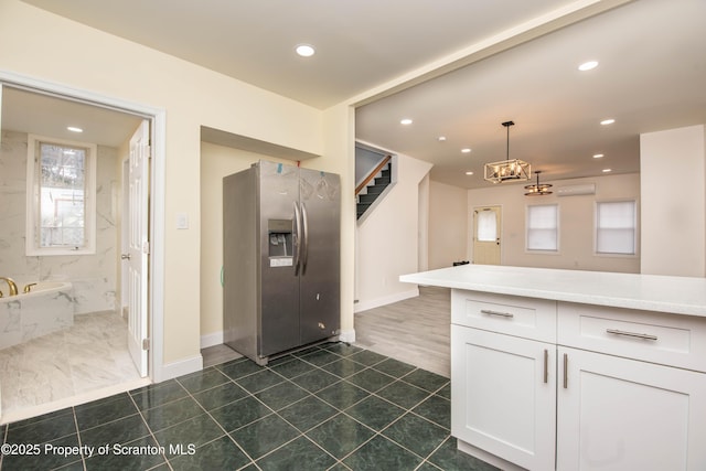 kitchen featuring recessed lighting, white cabinetry, stainless steel refrigerator with ice dispenser, light countertops, and decorative light fixtures