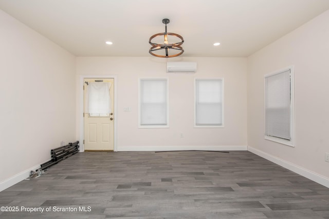 spare room featuring recessed lighting, wood finished floors, and a wall unit AC