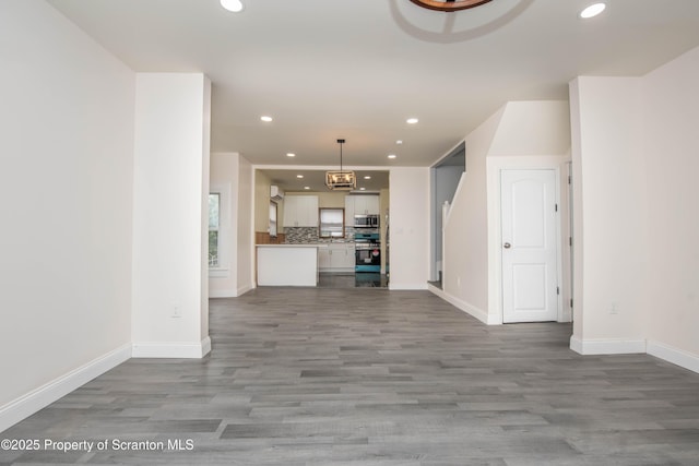 unfurnished living room featuring baseboards, wood finished floors, and recessed lighting
