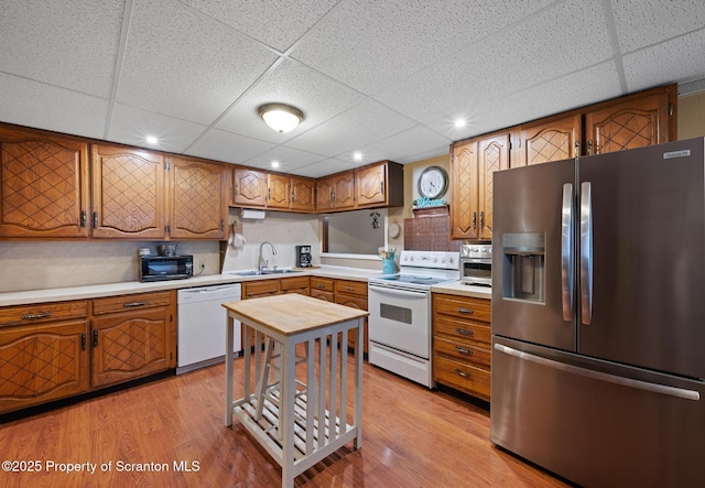 2211 Myrtle St, Scranton, PA 18510 - kitchen with white appliances, a drop ceiling, light countertops, brown cabinetry, and light wood finished floors